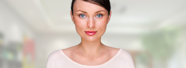 Крупный план портрета молодой красивой деловой женщины, стоящей у себя в офисе или дома и смотрящей в камеру
