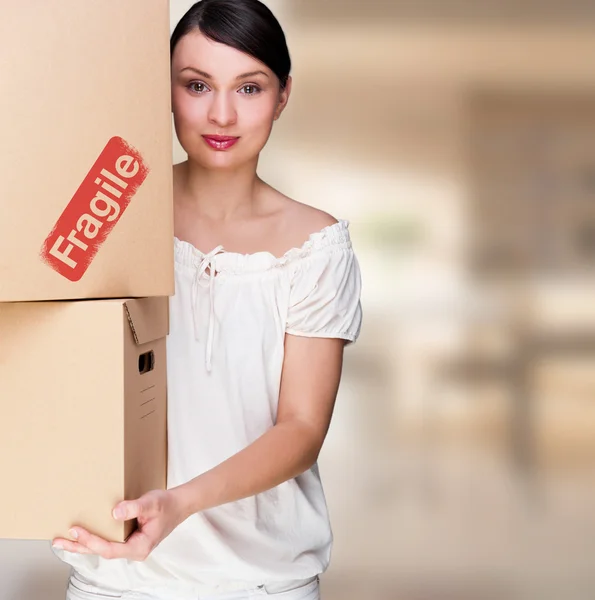 Retrato de close-up de uma jovem com caixas movendo-se para sua nova casa. Mulher feliz em sua nova casa devido ao conceito de hipoteca — Fotografia de Stock