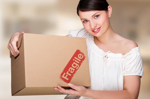 Close-up portrait of a young woman with boxes moving to her new home. Happy woman at her new home due to mortgage concept — 스톡 사진