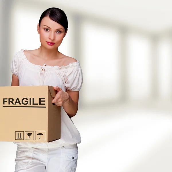 En kvinna med en låda inuti kontorsbyggnad eller heminredning. paketet tecken på låda — Stockfoto