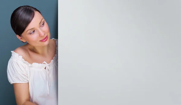 Close-up de jovem, mulher bonita de pé perto enorme placa em branco e segurando-o — Fotografia de Stock