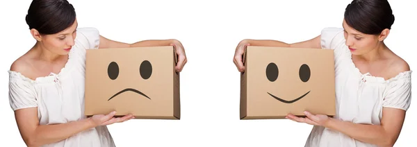 Femme attrayante avec des boîtes faisant un retrait. Sourire et visages tristes illustrés sur des boîtes. Différents concepts mobiles — Photo