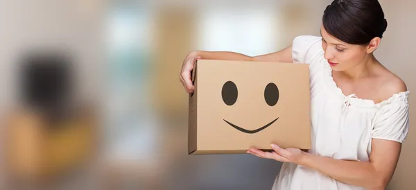 Attraktive Frau mit Schachtel, die eine Entfernung macht. Lächeln Gesicht auf Box dargestellt. leichtes, fröhliches, unbeschwertes Umzugskonzept — Stockfoto