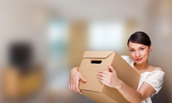 Smiling woman at her home holding boxes. She is Moving at her new home. Mortgage concept — Stock Photo, Image