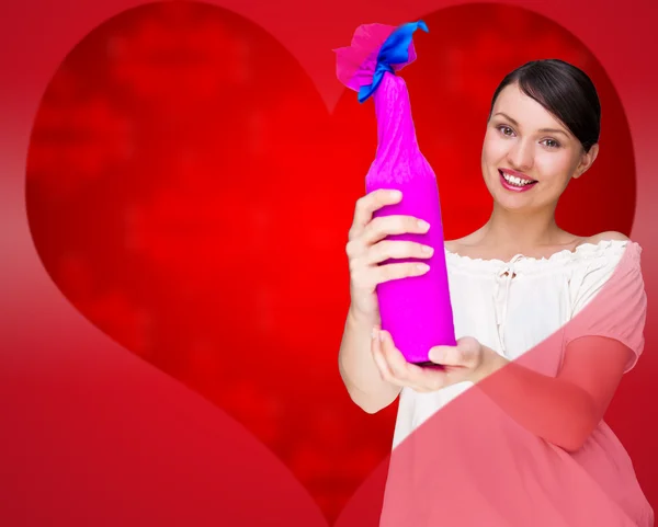 Retrato de una joven mujer bonita sosteniendo botella de vino prefecto en paquete decorativo de regalo contra el amor fondo de San Valentín con forma de corazón — Foto de Stock