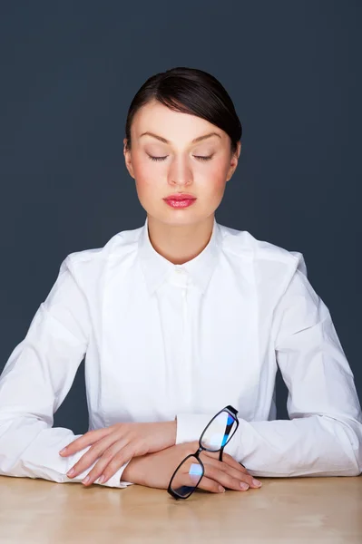 Verveeld zakenmensen: vrouw die aan bureau met zit gesloten ogen. jonge Kaukasische zakenvrouw op haar kantoor — Stockfoto
