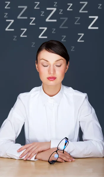 Gelangweilte Geschäftsleute: Frau sitzt mit geschlossenen Augen am Schreibtisch. junge kaukasische Geschäftsfrau in ihrem Büro — Stockfoto
