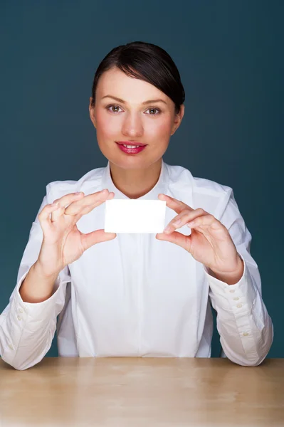 Молодая предпринимательница показывает свою визитку - сидит у себя в офисе — стоковое фото