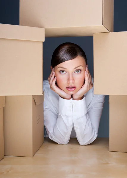 Retrato de una joven rodeada de muchas cajas. Mucho concepto de trabajo — Foto de Stock