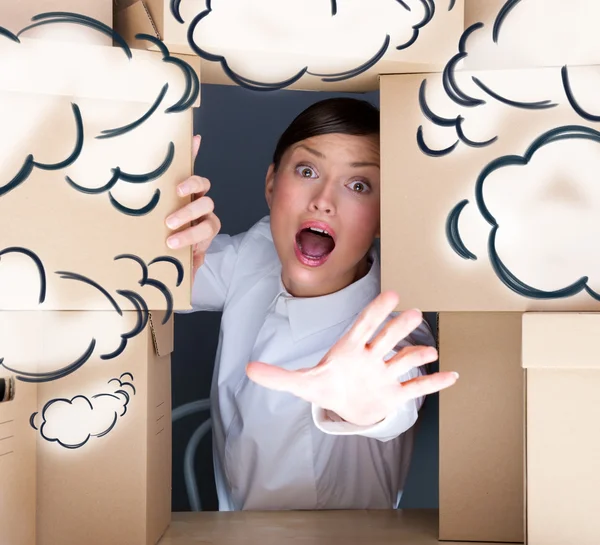 Portrait of young woman surrounded by lots of boxes. Lots of work concept. Help needed. Blank cloud balloons overhead — Stock Photo, Image