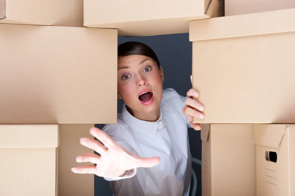 Portrait of young woman surrounded by lots of boxes. Lots of work concept — Stock Photo, Image