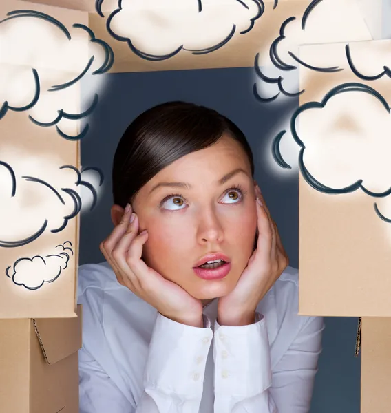 Porträt einer jungen Frau, umgeben von vielen Kisten. Viel Arbeit. Hilfe nötig. leere Wolkenballons über dem Kopf — Stockfoto