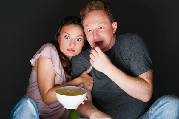 Um casal assistindo a um filme assustador e assustou-os tanto que eles estão gritando — Fotografia de Stock