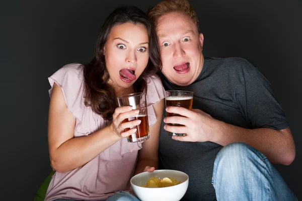 Um casal assistindo a um filme assustador e assustou-os tanto que eles estão gritando — Fotografia de Stock