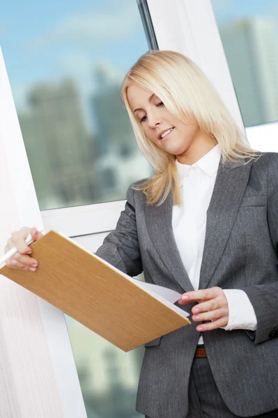 Retrato de jovem empresária vestindo roupas formais dando contrato para assinar em seu escritório — Fotografia de Stock