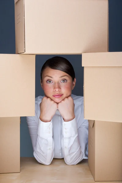 Portrait of young woman surrounded by lots of boxes. Lots of work concept Stock Picture