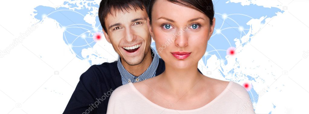 Handsome friendly couple in futuristic interface standing in front of world map with glowing hot points location and connection lines
