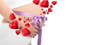 Image of pregnant woman touching her belly with hands. Violet tape on her belly. Beautiful red hearts are flying around her belly clipart