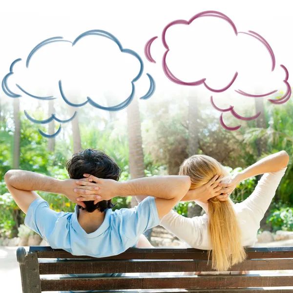 Smiling beautiful couple sitting on a bench at summer park and dreaming about something — Stock Photo, Image