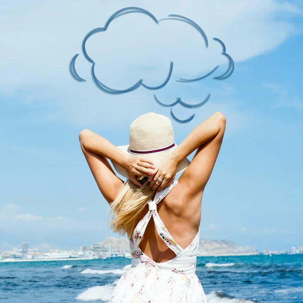 Junge modische Frau mit Hut und elegantem Kleid am Strand. Foto von hinten. leerer Wolkenballon über Kopf — Stockfoto