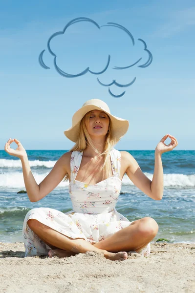 Retrato de mujer joven con sombrero de verano y vestido elegante sofistico meditando sentado en pose de loto en la arena en la playa. Globo nuboso en blanco —  Fotos de Stock
