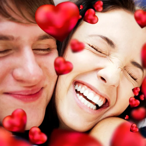 Close-up de jovem casal abraçando e muito feliz por estar juntos. Conceito Valentine. Corações vermelhos estão voando em torno deles — Fotografia de Stock
