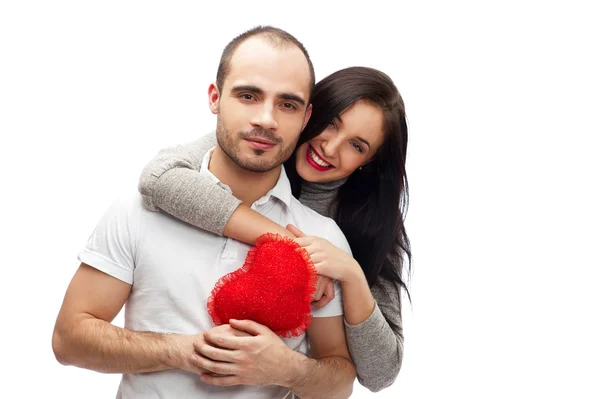 Feliz joven pareja adulta con el corazón rojo sobre fondo blanco, abrazando y riendo — Foto de Stock