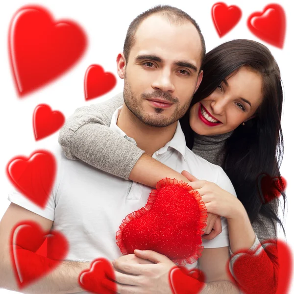 Vacker ung kärlek par embracing mot en vit bakgrund och många röda hjärtan flyger runt dem — Stockfoto