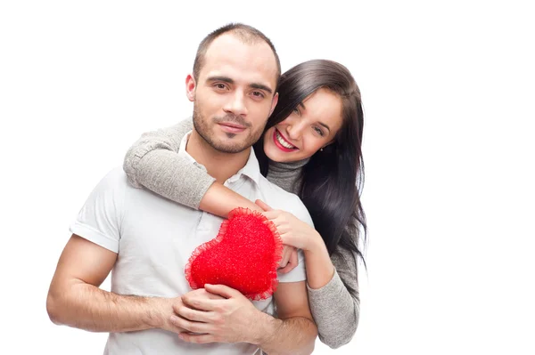 Glückliches junges erwachsenes Paar mit rotem Herz auf weißem Hintergrund, umarmt und lacht — Stockfoto