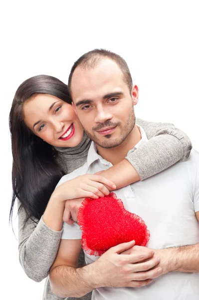 Feliz jovem casal adulto com coração vermelho no fundo branco, abraçando e rindo — Fotografia de Stock