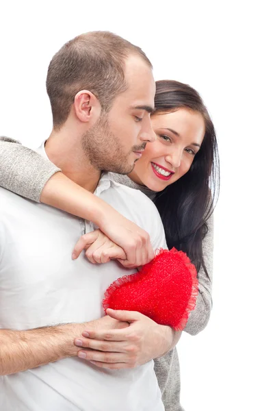 Happy young adult couple with red heart on white background, embracing and laughing — Stock Photo, Image
