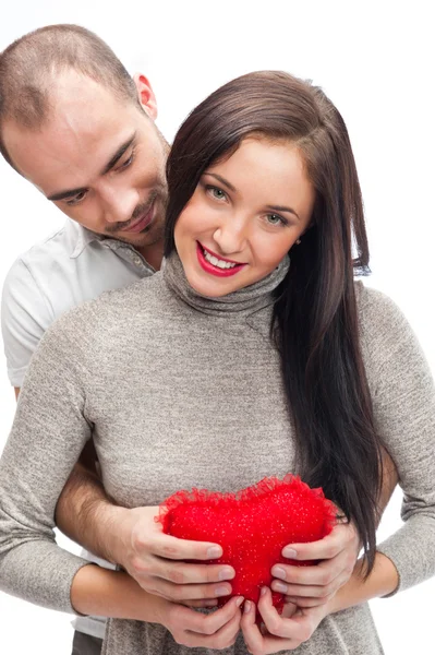 Boldog, fiatal felnőtt pár piros szív fehér háttér, átfogó, és nevetve — Stock Fotó