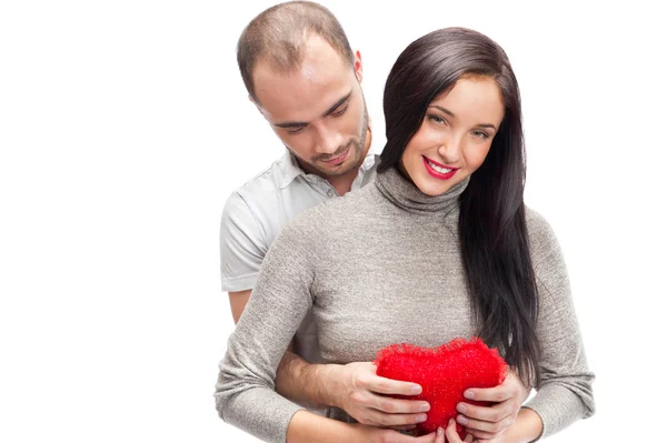 快乐的年轻成人夫妻用拥抱着笑着，在白色背景上的红色心 — 图库照片