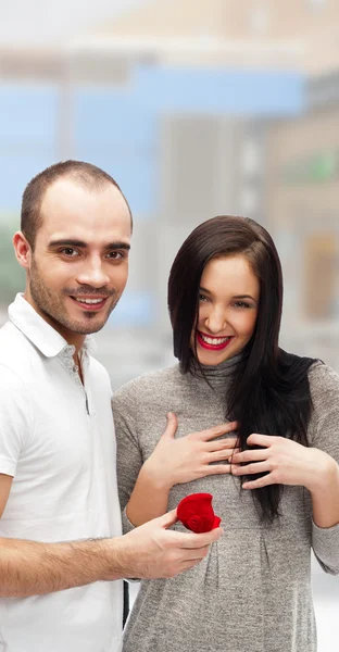Portret van een gelukkig volwassen man gifting aan zijn vrouw een ring aan haar verrassen op hun datum — Stockfoto