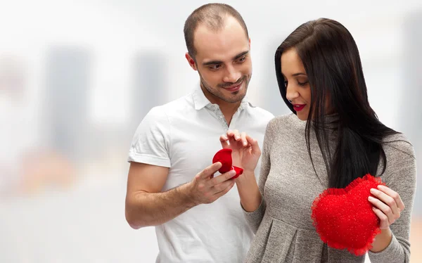 Portrait of a happy adult man gifting to his wife a ring to surprise her on their date Stock Picture