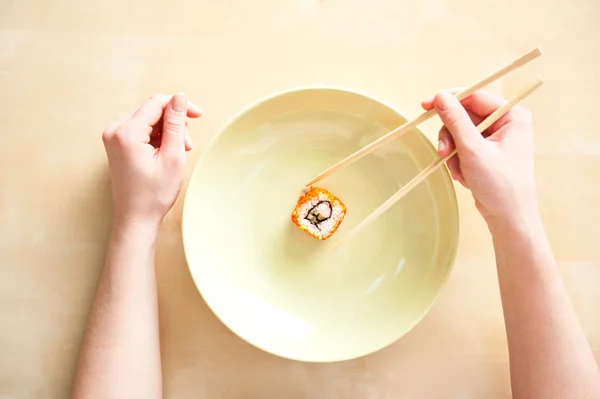 Woman holding sushi with chopsticks top view — Stock Photo, Image