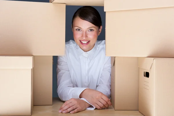 Retrato de una joven rodeada de muchas cajas. Mucho concepto de trabajo . —  Fotos de Stock