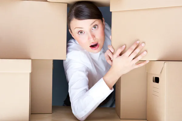 Retrato de una joven rodeada de muchas cajas. Mucho concepto de trabajo . —  Fotos de Stock