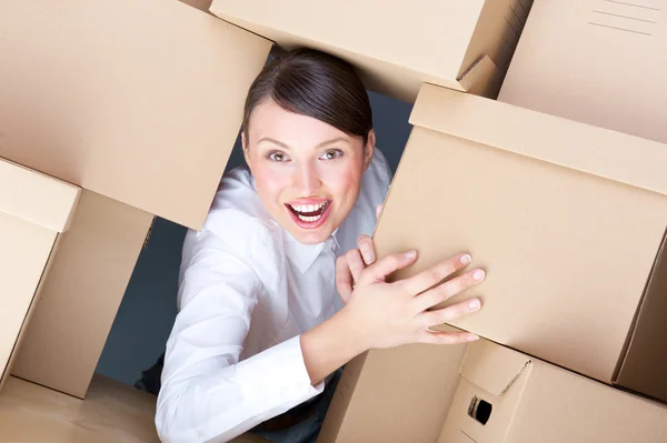 Retrato de una joven rodeada de muchas cajas. Mucho concepto de trabajo . — Foto de Stock