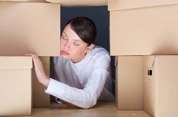 Retrato de mujer joven rodeado de un montón de cajas. montón de concepto de trabajo. — Stockfoto