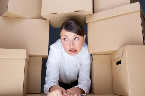 Retrato de una joven rodeada de muchas cajas. Mucho concepto de trabajo . — Foto de Stock