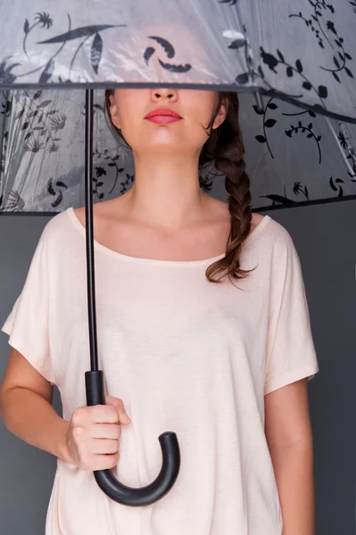 Jeune femme à la mode tenant parapluie debout sur fond gris — Photo