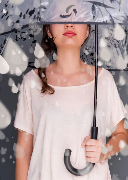 Portrait of beautiful young fashionable woman standing under umbrella and catching fake water drops of rain. Safety concept — Stock Photo, Image