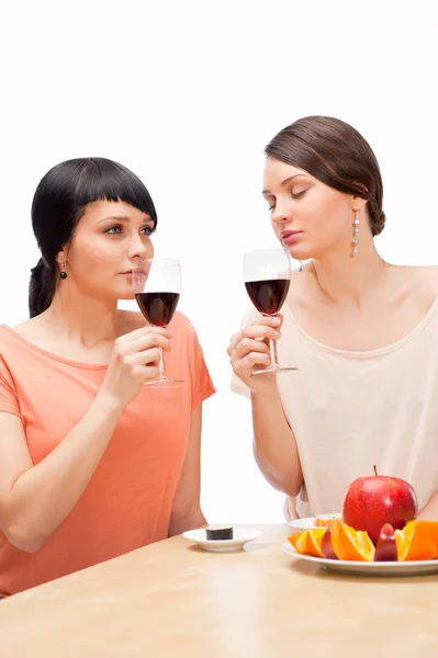Mulheres alegres comendo frutas e bebendo vinho tinto — Fotografia de Stock