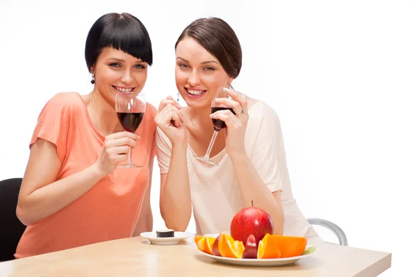 Veselé ženy jíst ovoce a pití červeného vína — Stock fotografie