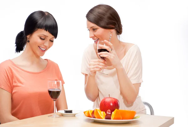 Mujeres alegres comiendo frutas y bebiendo vino tinto — Foto de Stock