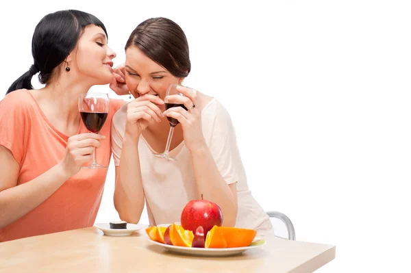 Веселые женщины едят фрукты и пьют красное вино — стоковое фото