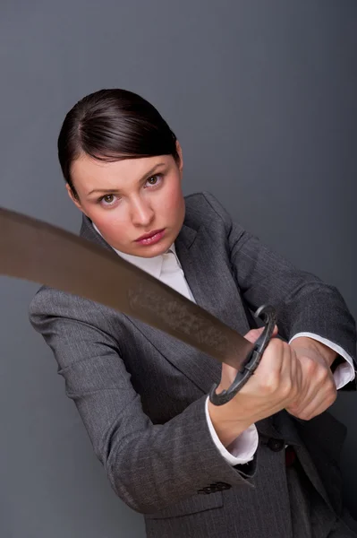 Mulher de negócios mostrando determinação enquanto segura uma espada — Fotografia de Stock
