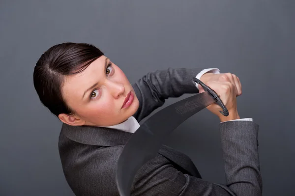 Mulher de negócios mostrando determinação enquanto segura uma espada — Fotografia de Stock
