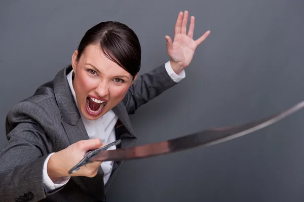 Mujer de negocios mostrando determinación mientras sostiene una espada — Foto de Stock